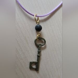 Goldtone Key Pendant Necklace with Black Lava Bead